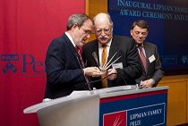 A small group of people at a podium during an award ceremony, with "Lipman Family Prize" and "Penn" branding visible in the background.